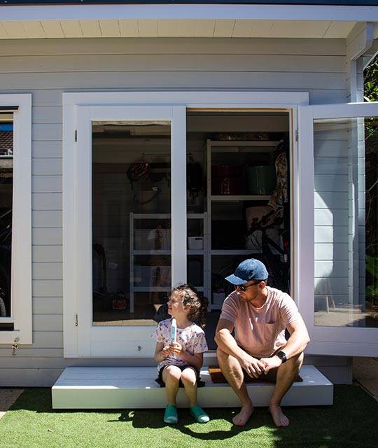 Father and daughter sitting on the porch of storage shed