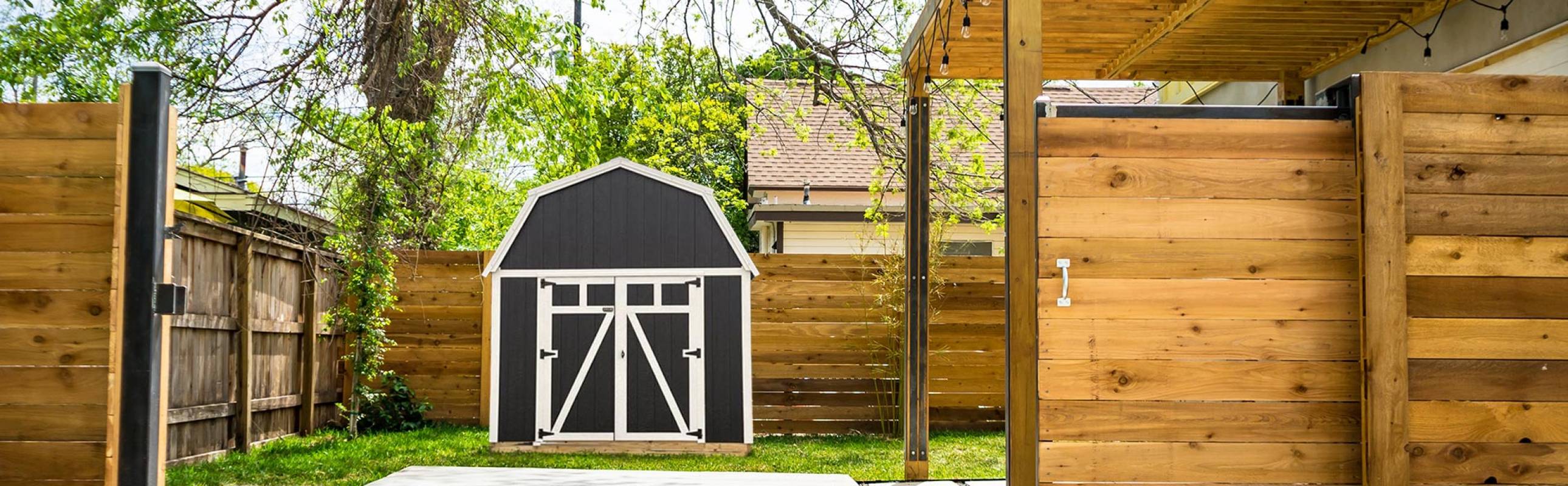 Black with white trim Stellar Lofted Barn in backyard